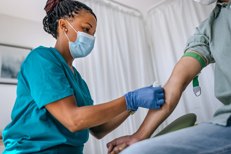 Nurse taking blood sample from patient.
